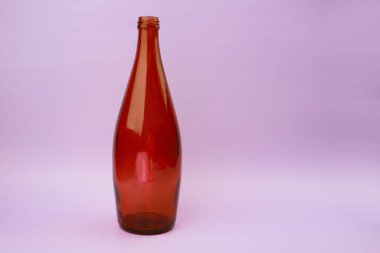 Mor arka planda boş kahverengi cam şişe. Kırpma yolu dahil.