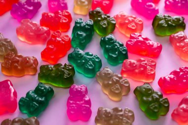 Pembe arka planda renkli ayıcık şekerleri.