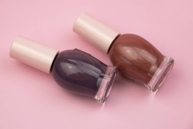 Pembe arka planda tırnak cilası şişeleri. Güzellik ve moda konsepti.