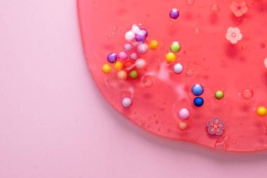 Renkli jel dokusu, baloncuklu temiz cilt kremi ve dekoratif figürler arka plan, şeffaf güzellik serumu, renkli kozmetik ürünler yakın plan.