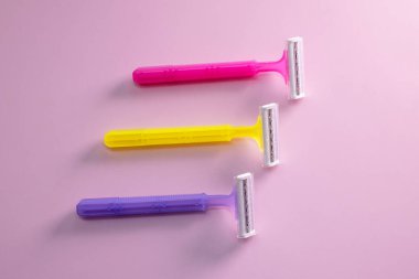 Pembe arka planda saç kesimi için tek kullanımlık tıraş bıçağı.