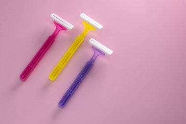 Pembe arka planda saç kesimi için tek kullanımlık tıraş bıçağı.