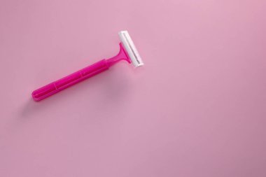 Pembe arka planda saç kesimi için tek kullanımlık tıraş bıçağı.