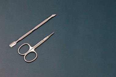 Manikür seti, profesyonel bakım seti, tırnak makası ve tırnak makası, karanlık arka planda tırnaklar ve ayak tırnakları için profesyonel paslanmaz çelik pedikür aletleri.