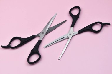 Pembe arka planda saç kesme makası. Üst manzara, düz uzanma