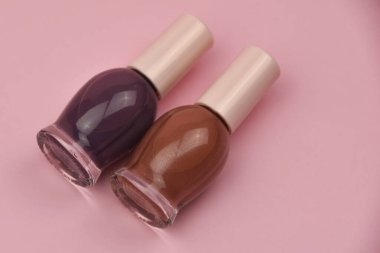 Pembe arka planda tırnak cilası şişeleri. Kopyalama alanı olan üst görünüm