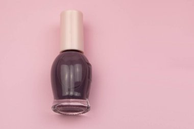 Pembe arka planda izole edilmiş oje şişesi. Kopyalama alanı olan üst görünüm