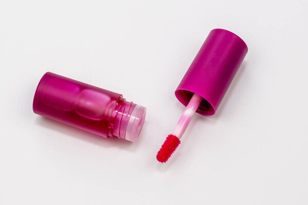 Розовый блеск для губ на белом фоне, жидкая помада
