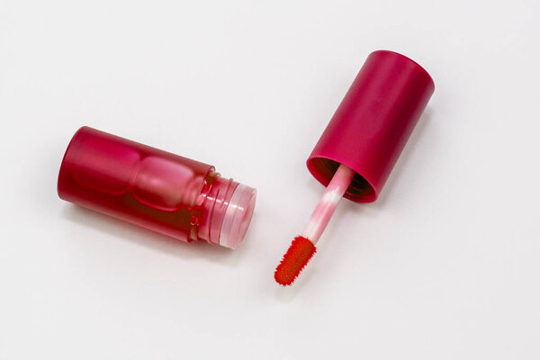 Розовая помада и кисть на белом фоне. Вид сверху.