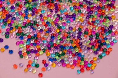 Pembe arka planda renkli boncuklar, üst manzara. Boşluğu kopyala.