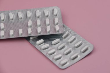 Haplar ve kapsüller pembe arka planda su topladı. Kapat..