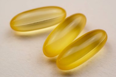 Beyaz arka planda morina ciğeri yağı Omega 3 jel kapsülleri.