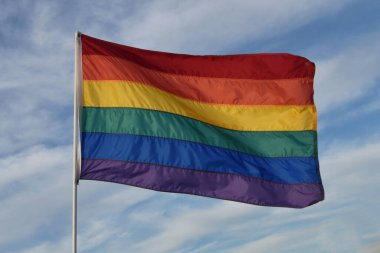 Mavi gökyüzüne karşı renkli gökkuşağı gay gurur bayrağı, LGBTQ sembolü