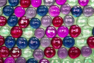 Bej arkaplanda çok renkli cam boncuklar, yakın plan.