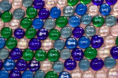 Pembe arka planda çok renkli cam boncuklar..