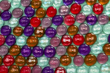 Mavi arka planda çok renkli cam boncuklar..