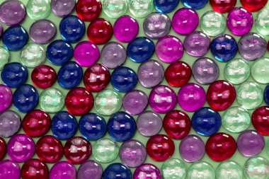 Bej arka planda çok renkli cam boncuklar.