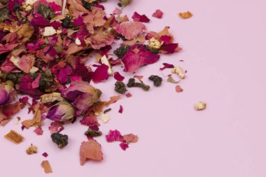 Pembe arka planda kurumuş gül yaprakları, yakın planda mor gül çiçekleri, romantik çiçek deseni.