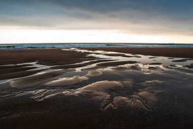 Dalgaların alçak gelgitte uzun süre maruz kaldığı güzel deniz manzarası