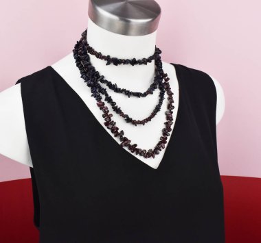 Beyaz bir mankenin üzerindeki ifade kolyesi, devasa el yapımı takılar.