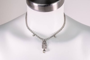 Beyaz bir mankenin üzerindeki ifade kolyesi, devasa el yapımı takılar.