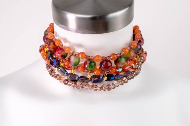 Beyaz bir mankenin üzerindeki ifade kolyesi, devasa el yapımı takılar.