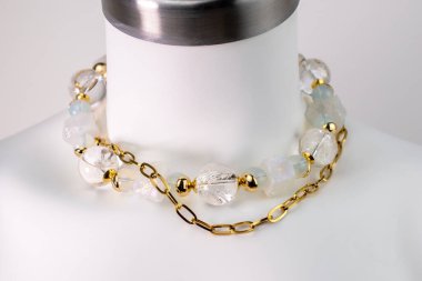 Beyaz bir mankenin üzerindeki ifade kolyesi, devasa el yapımı takılar.