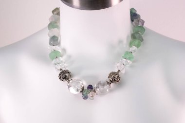 Beyaz bir mankenin üzerindeki ifade kolyesi, devasa el yapımı takılar.