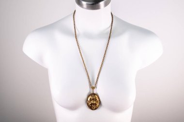 Beyaz bir mankenin üzerindeki ifade kolyesi, devasa el yapımı takılar.