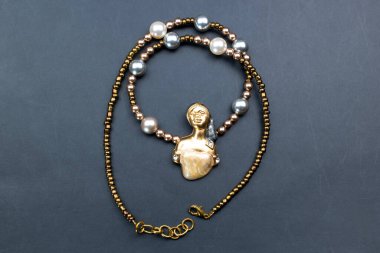 Siyah arka planda inci ve boncuklu kolye..