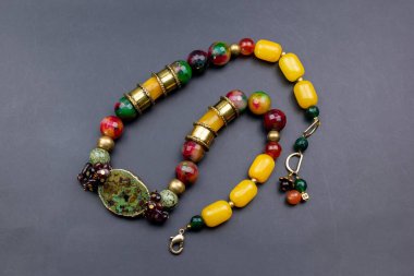 Tahtadaki çeşitli renkte boncuklardan yapılmış kolye.