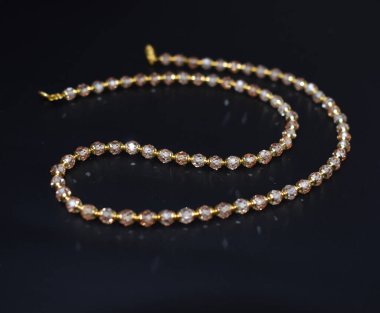 Yakından çekilen siyah arkaplanda sığ alan derinliğinde bir kolye.