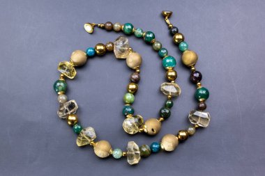 Gri arkaplanda çeşitli renk ve şekillerde boncuklar.