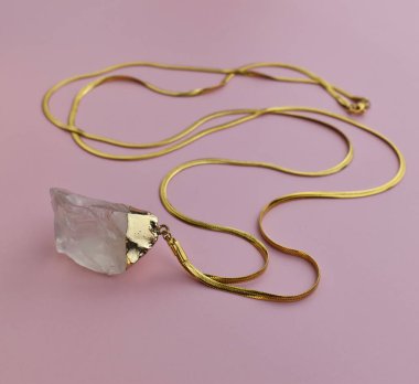 Pembe arka planda güzel altın bir kolye. Mücevher konsepti.