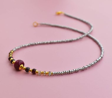 Pembe arka planda boncuklu kolye. Boncuklardan yapılmış bilezik..