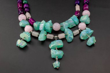 Siyah arka planda doğal taşlardan yapılmış bir kolye.