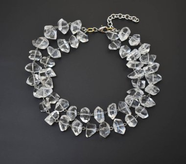 Siyah arka planda şeffaf taşlardan yapılmış kolye.