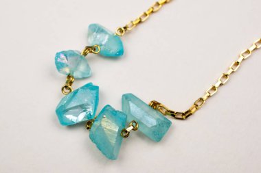 Beyaz arka planda turkuaz değerli taşlı kolye