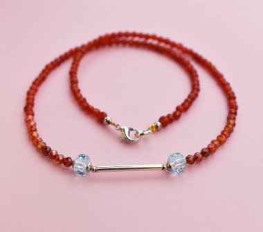 Pembe arka planda kolye, yakın plan, seçici odak