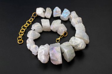 Siyah arka planda doğal taştan yapılmış bir kolye.