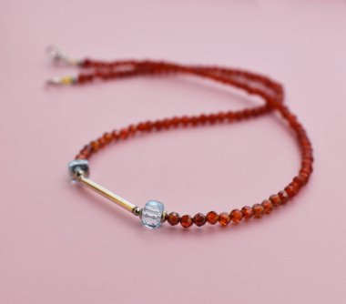 Kehribar boncuklar pembe arka planda izole edilmiş. Güzel moda aksesuarı.