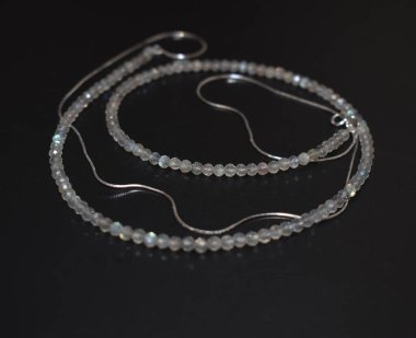 Siyah arka planda gümüş bilezik, yakın plan. Mücevher aksesuarları