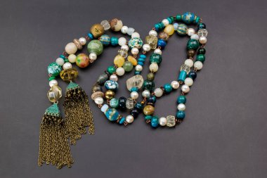 Gri bir arka planda renkli boncuklar. Mücevher ve aksesuarlar..