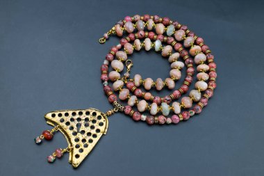 Siyah arka planda değerli taşlardan yapılmış kolye.