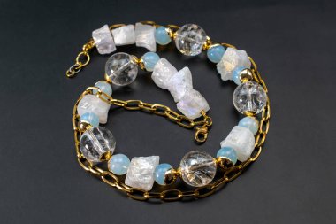 Siyah arka planda mavi taşlar olan kolye..