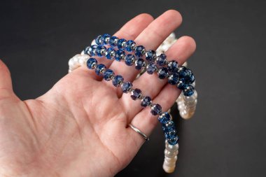 Siyah bir arka planda mavi taşlardan yapılmış bir bilezik..