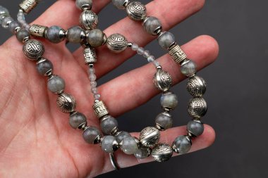 Koyu arkaplanda gümüş boncuklardan yapılmış bilezik.