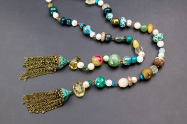 Siyah arkaplanda renkli kolyeler, yakın plan.