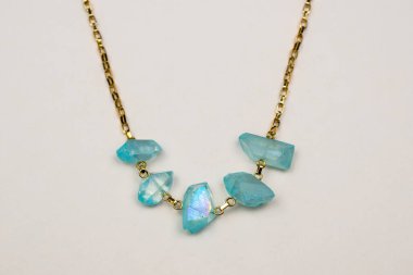 Beyaz arkaplanda turkuaz ve safir kolye