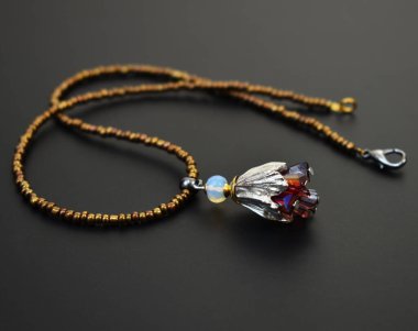 Siyah bir arkaplanda değerli bir taşla yakın plan kolye.